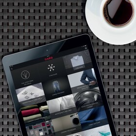 Чоловік, який встановлює температуру своєї парової духової шафи на смартфоні, використовуючи додаток my AEG