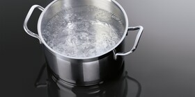 Вода, кипящая в кастрюле на индукционной панели AEG